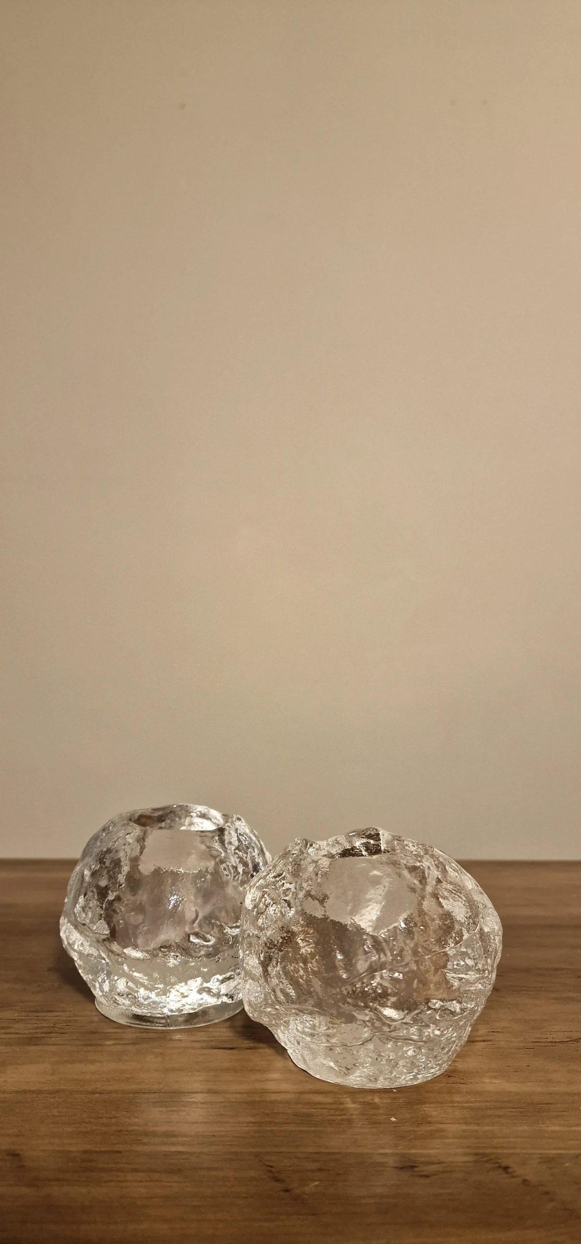 Två eleganta värmeljushållare i glas med en organisk design, perfekta för att skapa en mysig atmosfär