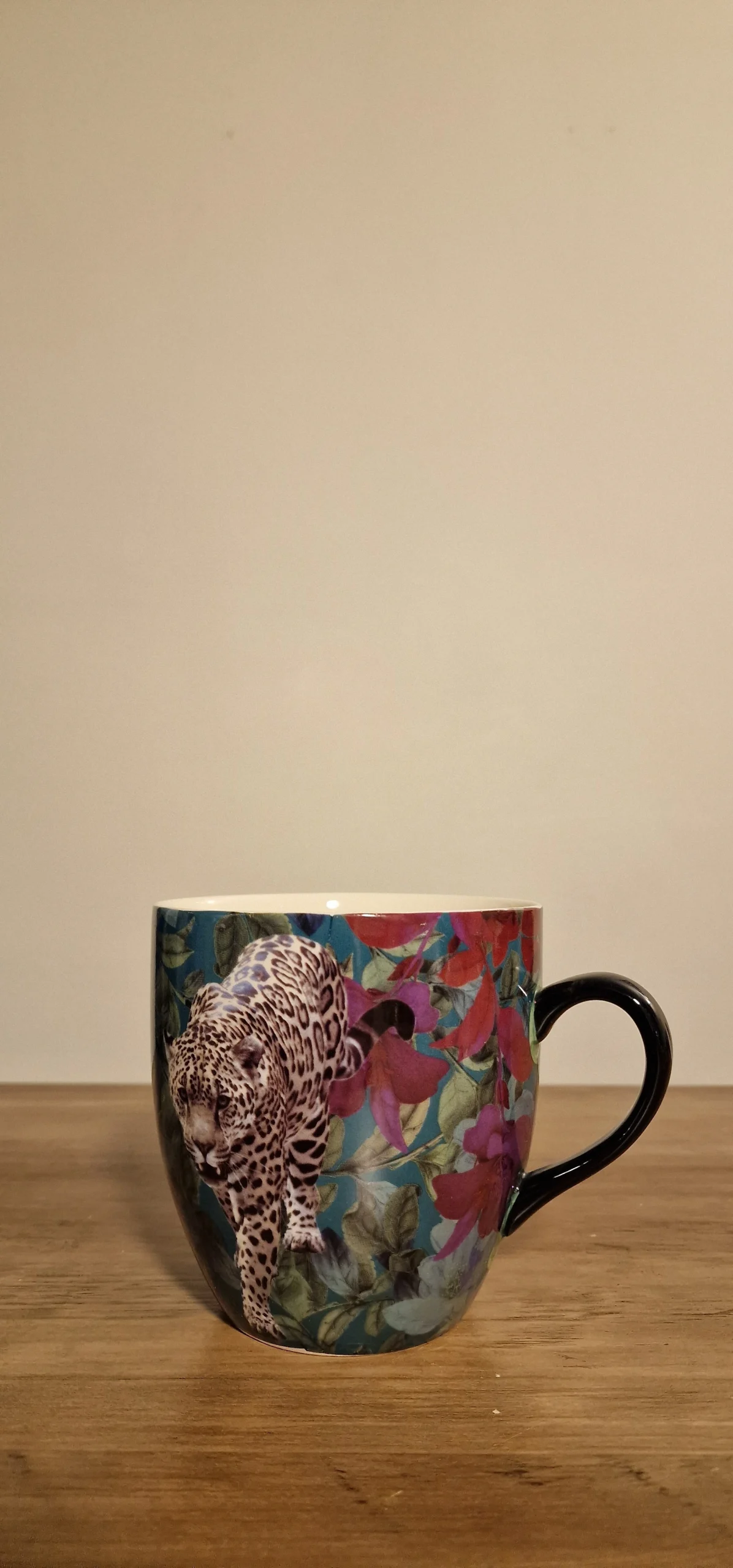 Färgglad mugg med leopardmotiv och blommiga detaljer, perfekt för en unik och stilfull kaffestund.