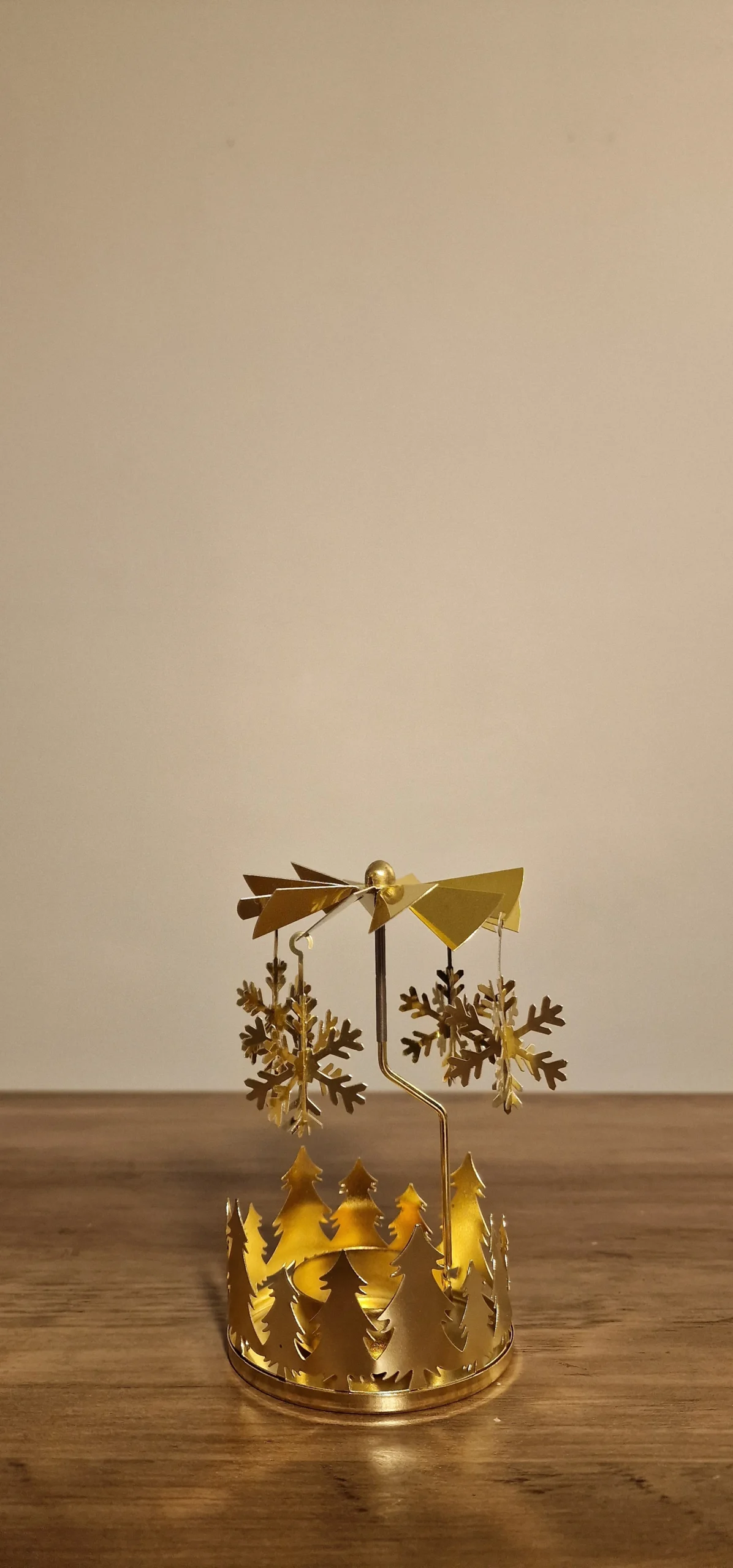 Gyllene juldekoration med snöflingor och granar, designad för att skapa en varm och festlig stämning i hemmet